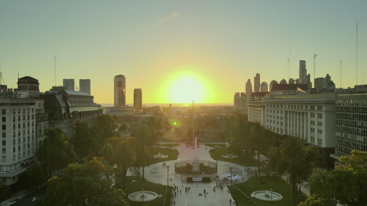Aerial Drone Scene flying forward May Square to Casa Rosada, Buenos Aires, Argentina, the presidential pink house, Plaza de Mayo, warm dawn morning sun, backlight flare and reflections.