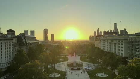 aerial drone scene flying forward may square to casa rosada, buenos aires, argentina, the presidential pink house, plaza de mayo, warm dawn morning sun, backlight flare and reflections.