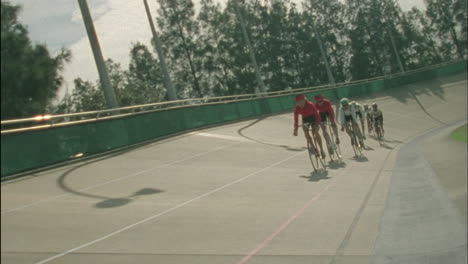 cyclists race around a curved track