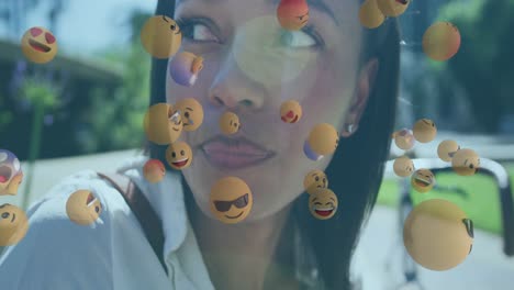 multiple face emojis floating against african american woman having a snack