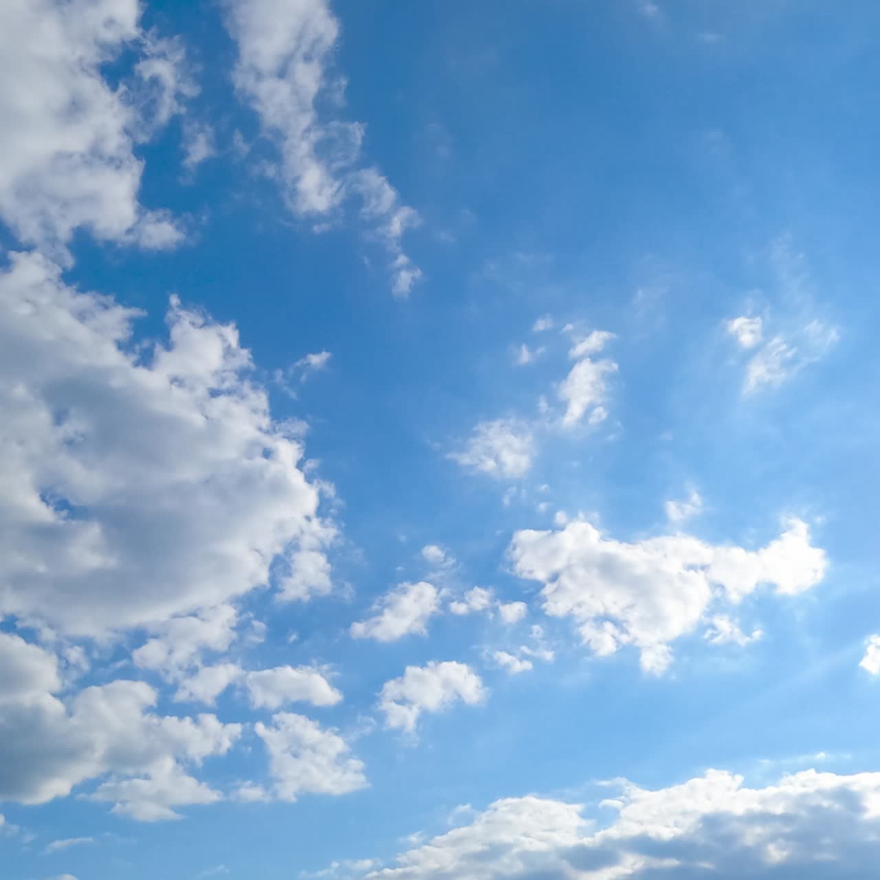 Clouds formation in the atmosphere. Beautiful cloudscape gathering quickly in the blue sky. Timelapse