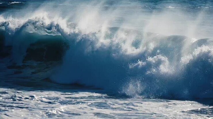 Large dark blue ocean wave crashing with white sea foam