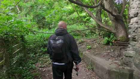 man and his dog exploring woodland castle ruins hiking in dense forest wilderness environment