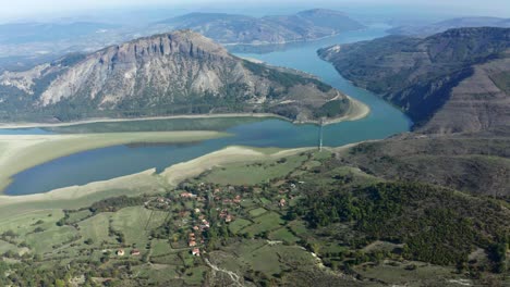 An-aerial-view-of-a-mountain-range-with-a-river-running-between-it,-surrounded-by-a-village-in-Bulgaria