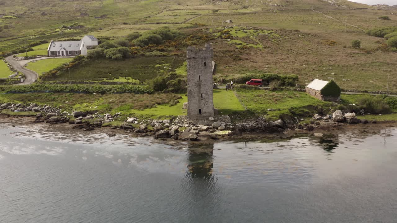 Grace O'Malley's Towerhouse constructed of stone on achill island shore, birds soar in sky