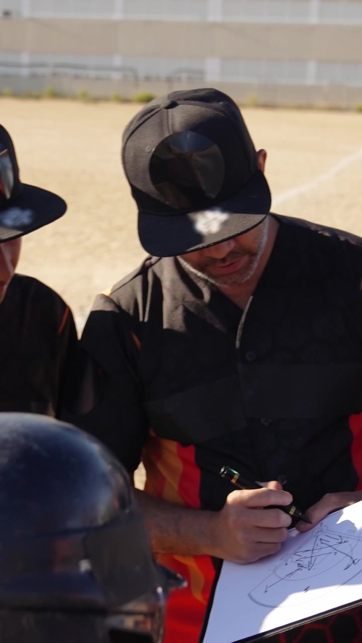 Allenatore di baseball che disegna schemi su una lavagnetta per i giocatori