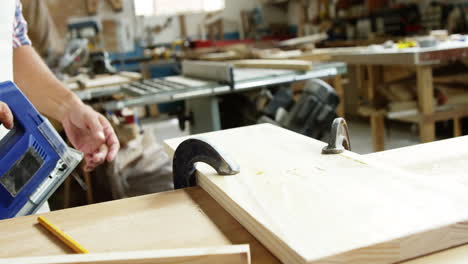 centrarse en la tabla de madera y el carpintero trabajando en ella