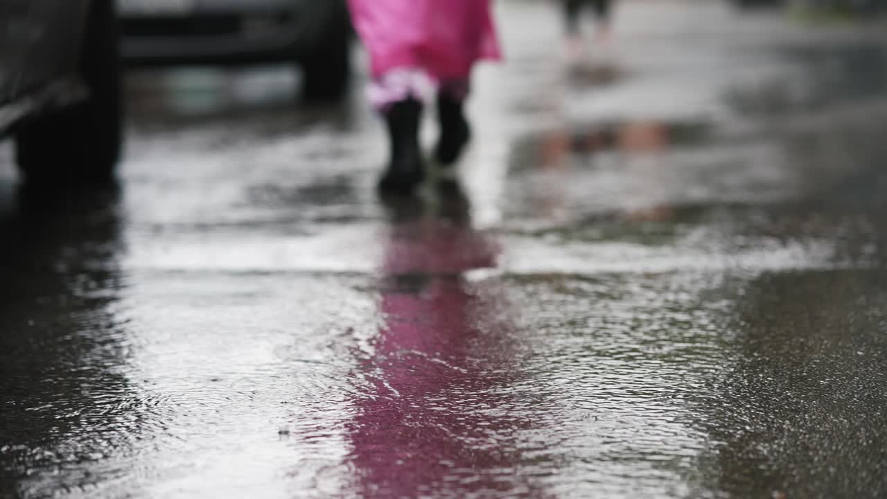 Child playing in puddles on a rainy day