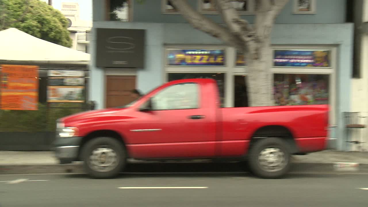 측면 창 3을 통해 보이는 산타모니카 캘리포니아의 거리를 따라 자동차가 이동합니다.
