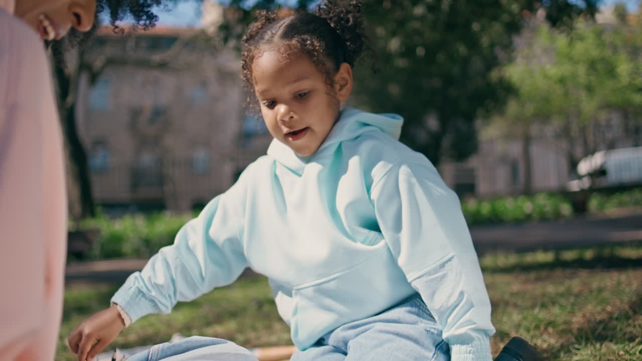 feliz niño dibujando picnic día soleado con la madre de cerca.