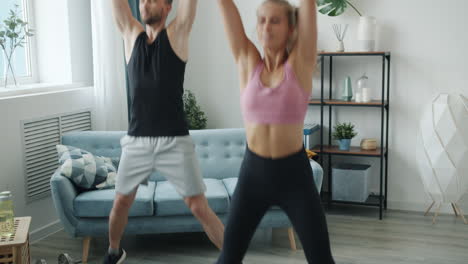 couple doing jumping jacks at home