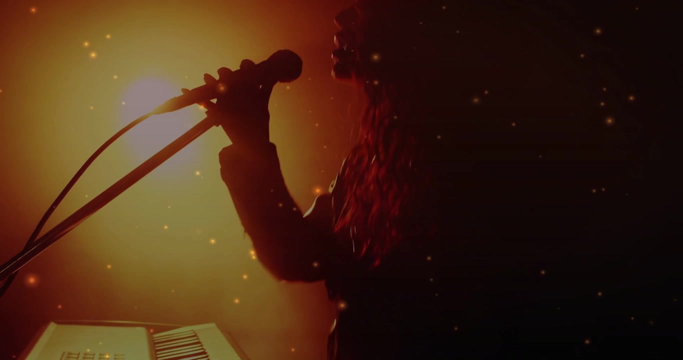 Woman playing keyboard, backlight rising, reaching mic and singing for music, particles floating