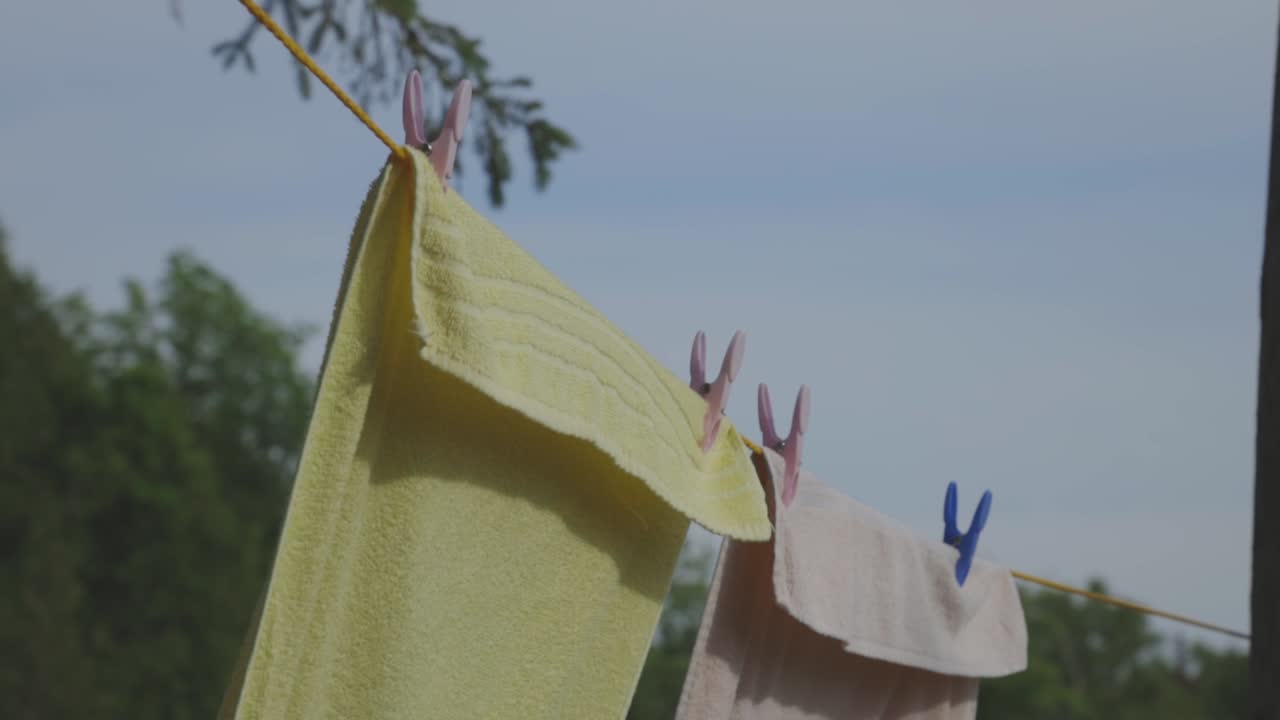 Drying Towels On The Clothesline With Clothes Pins On A Sunny Day - close up slowmo
