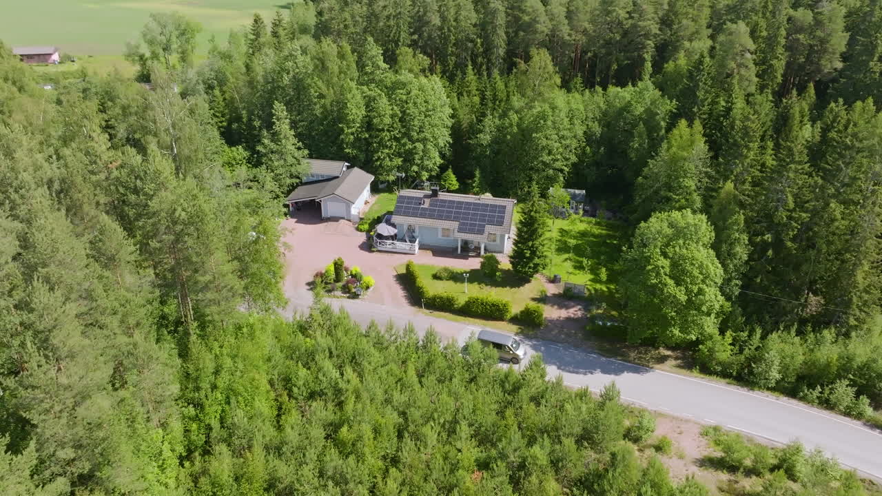 Aerial view of a van driving past a solar powered, detached house, summer day