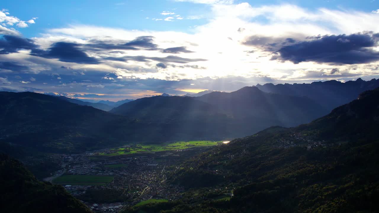 Vue drone sur les Alpes françaises au coucher du soleil, avec des nuages qui survolent les sommets.