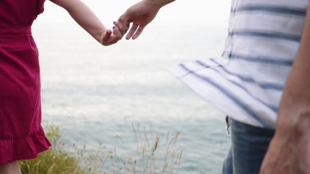 pareja amorosa besándose en un acantilado rocoso cerca del mar