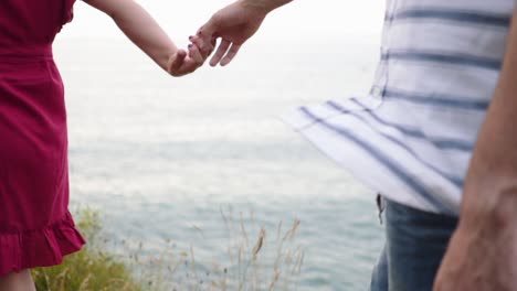 Loving-couple-kissing-on-rocky-cliff-near-sea