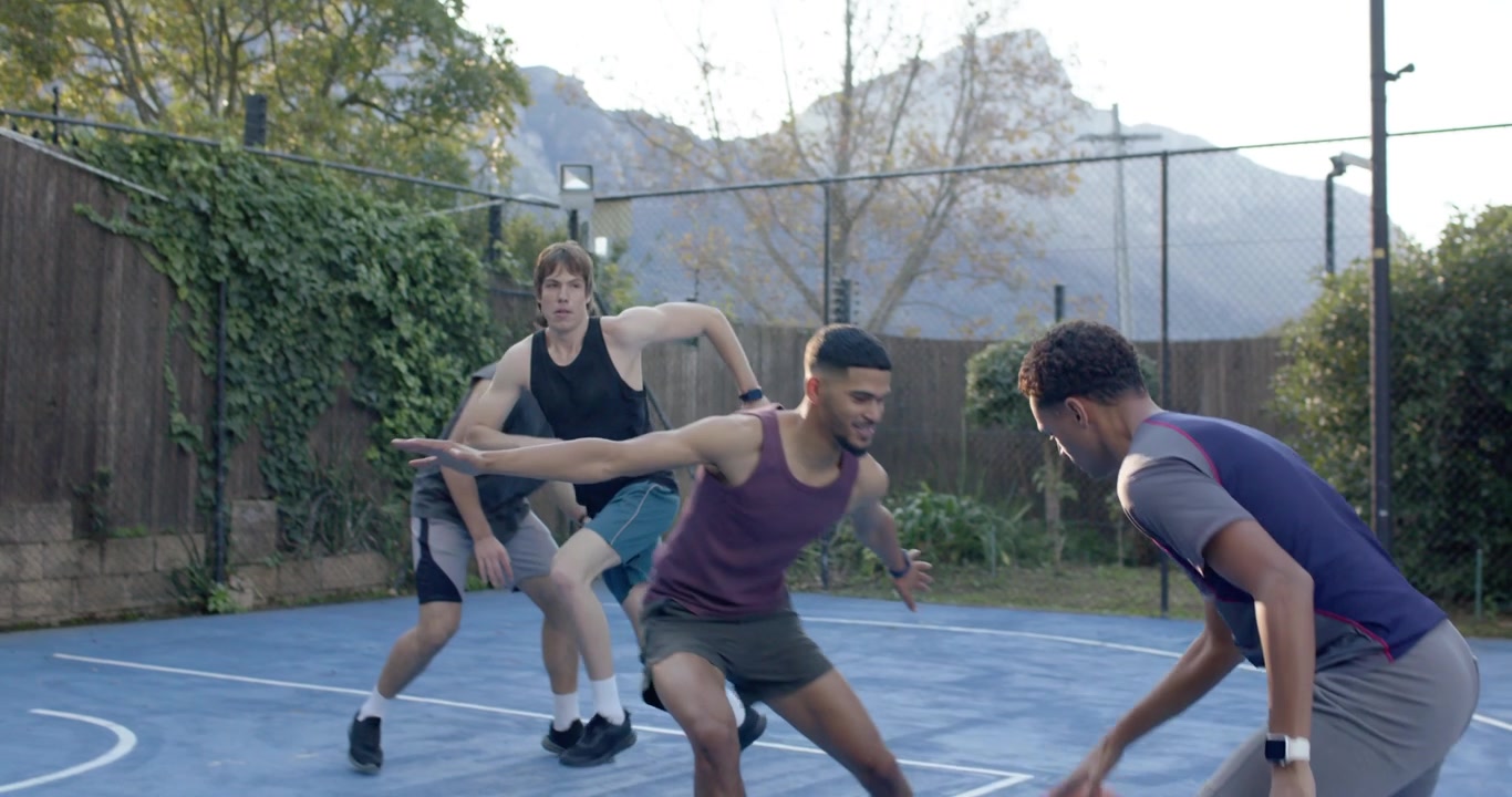 Hombres diversos, afroamericanos, en una cancha, regateando el balón con la defensa cerrándose, avanzando para anotar, espacio para texto.