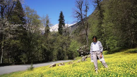 woman in a flower field in the mountains