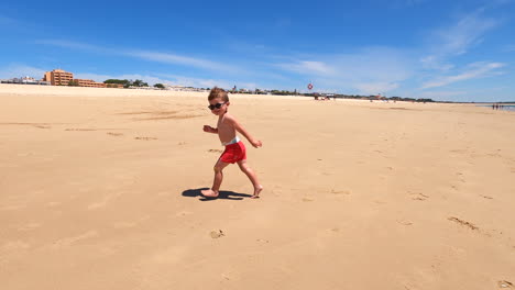 Kaukasischer-Kleinkindjunge-Im-Urlaub,-Der-Glücklich-Am-Sonnenstrand-Läuft