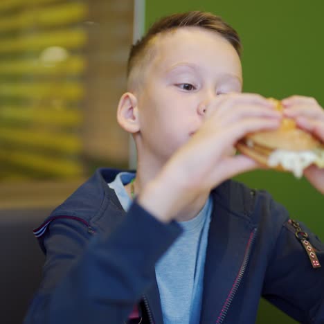 a boy in a fast food cafe. eating burgers and french fries in fast food cafes. harmful nutrition