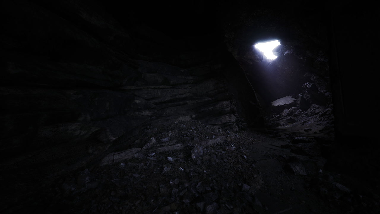 Shining light exposes jagged rocks and moist floor in cavern