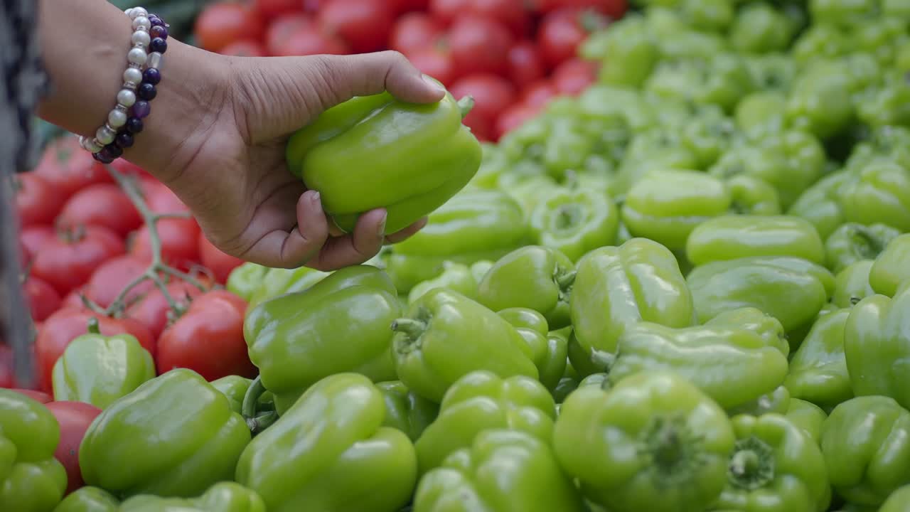mujer comprando pimientos verdes en un mercado