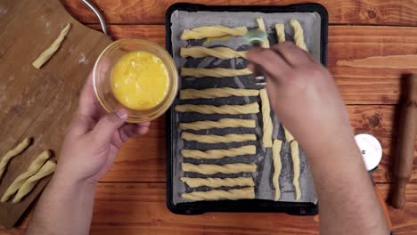 brushing scrambled egg under dough for baking