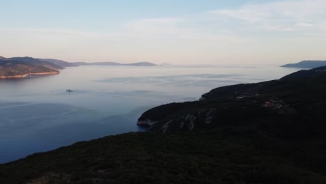 Elevated-view-of-serene-coast,-sea-mirroring-sky,-with-distant-hills