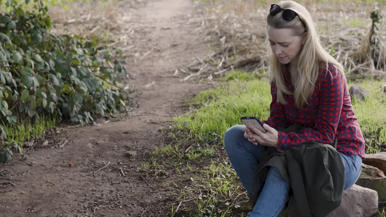 Woman using smartphone on trail