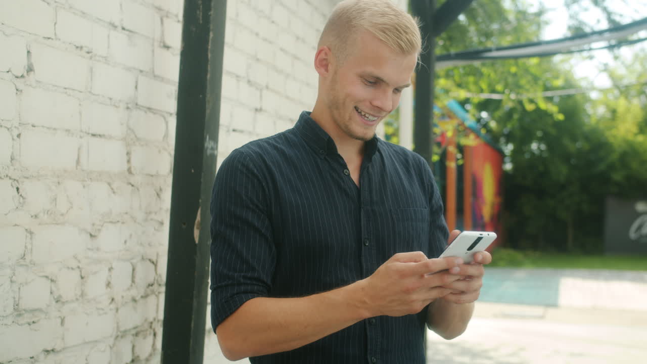 Giovane uomo che usa un cellulare all'aperto