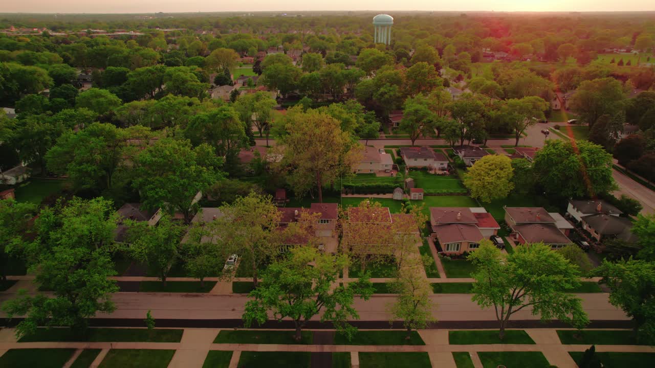 Vue aérienne de maisons de banlieue et de verdure à Chicago au coucher du soleil, présentant un quartier résidentiel paisible