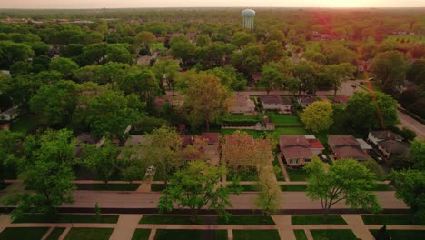 Aerial-view-of-Chicago-suburban-houses-and-greenery-during-sunset,-showcasing-a-peaceful-residential-area