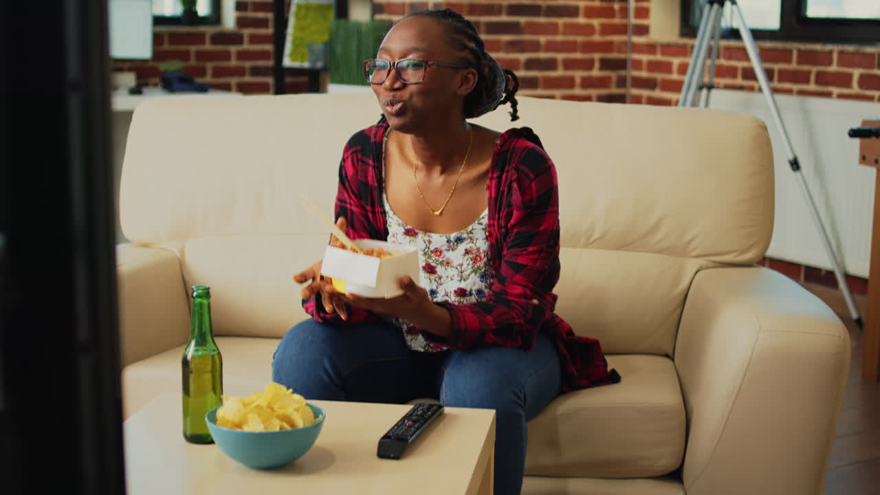 Ragazza afroamericana che mangia noodles con le bacchette