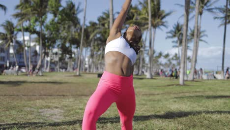 mujer deportiva relajada entrenando en un parque soleado