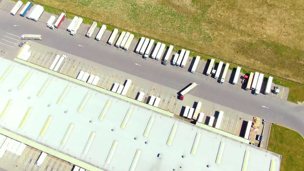 Luftfoto af et varehus. Logistikcenter i et industriområde set ovenfra. Luftfoto af lastbiler, der læsser ved et logistikcenter.