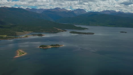 aerial cinematic drone high altitude grand lake shadow mountain grandby colorado rocky mountain national park entrance calm clear beautiful summer morning boating through islands forward reveal