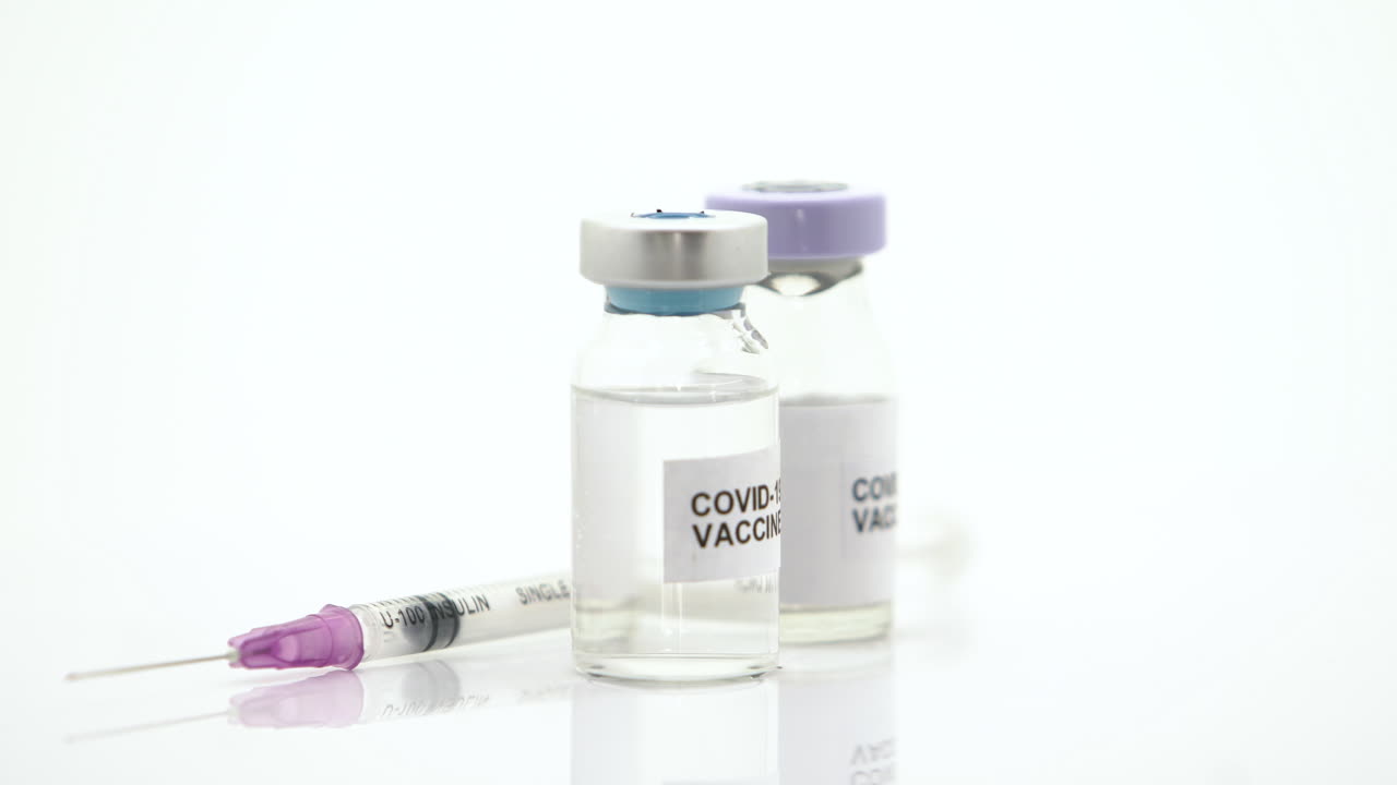 The Vaccines and syringes for preventing viruses revolves around on a white background