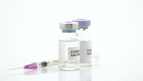 the vaccines and syringes for preventing viruses revolves around on a white background