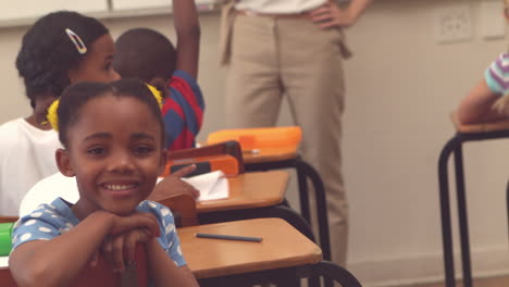 Cute-pupil-smiling-at-camera-in-classroom