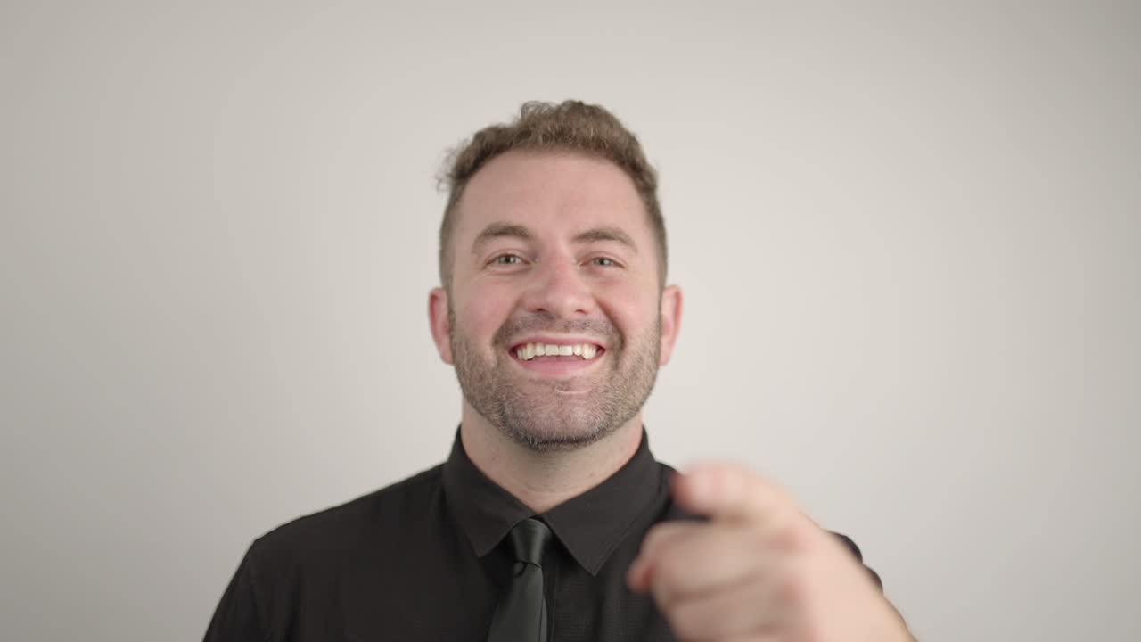 hombre sonriente apunta a la cámara