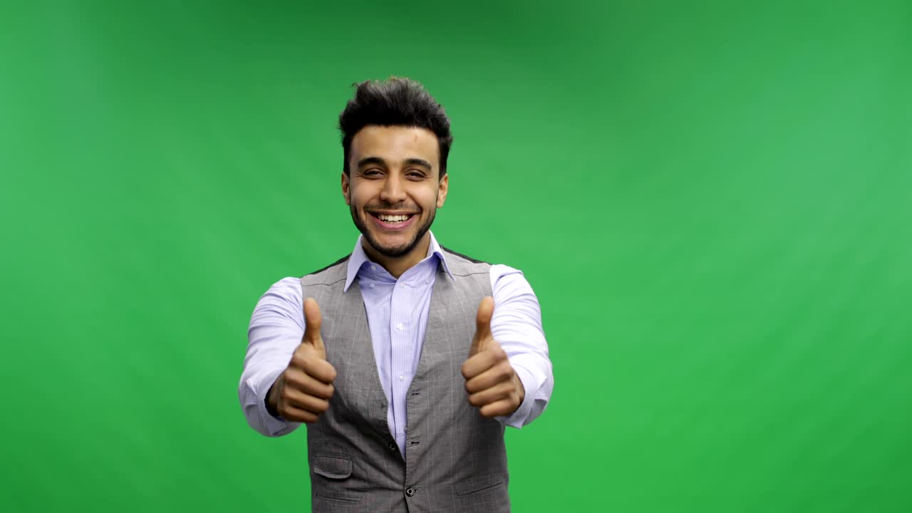 hombre de negocios sostiene los pulgares hacia arriba retrato sonriente feliz joven hombre de negocios alegre sobre pantalla verde clave de croma