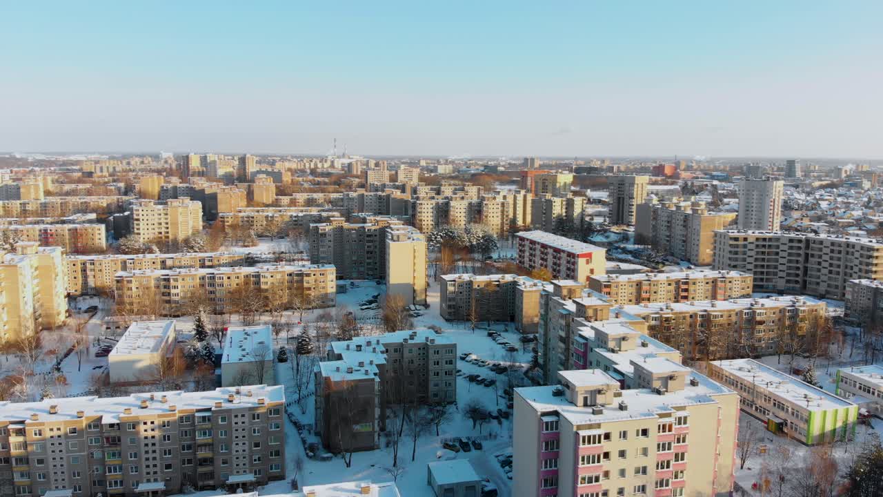 Luftaufnahme von Mehrfamilienhäusern im Winter, verschneite Umgebung, sonniger Tag, Flug über Wohnblöcke, Parallaxe, Litauen