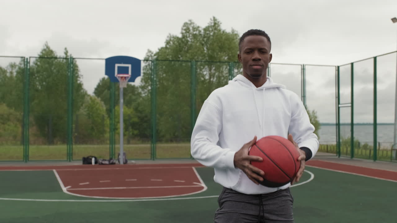 African American man with basketball on outdoor court