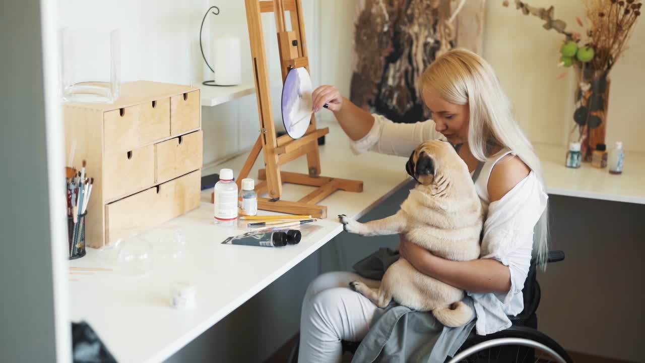 휠체어를 탄 어린 소녀가 유리에 그림을 그립니다