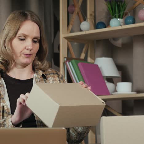 a woman works at home looks through parcels ready to be shipped 1