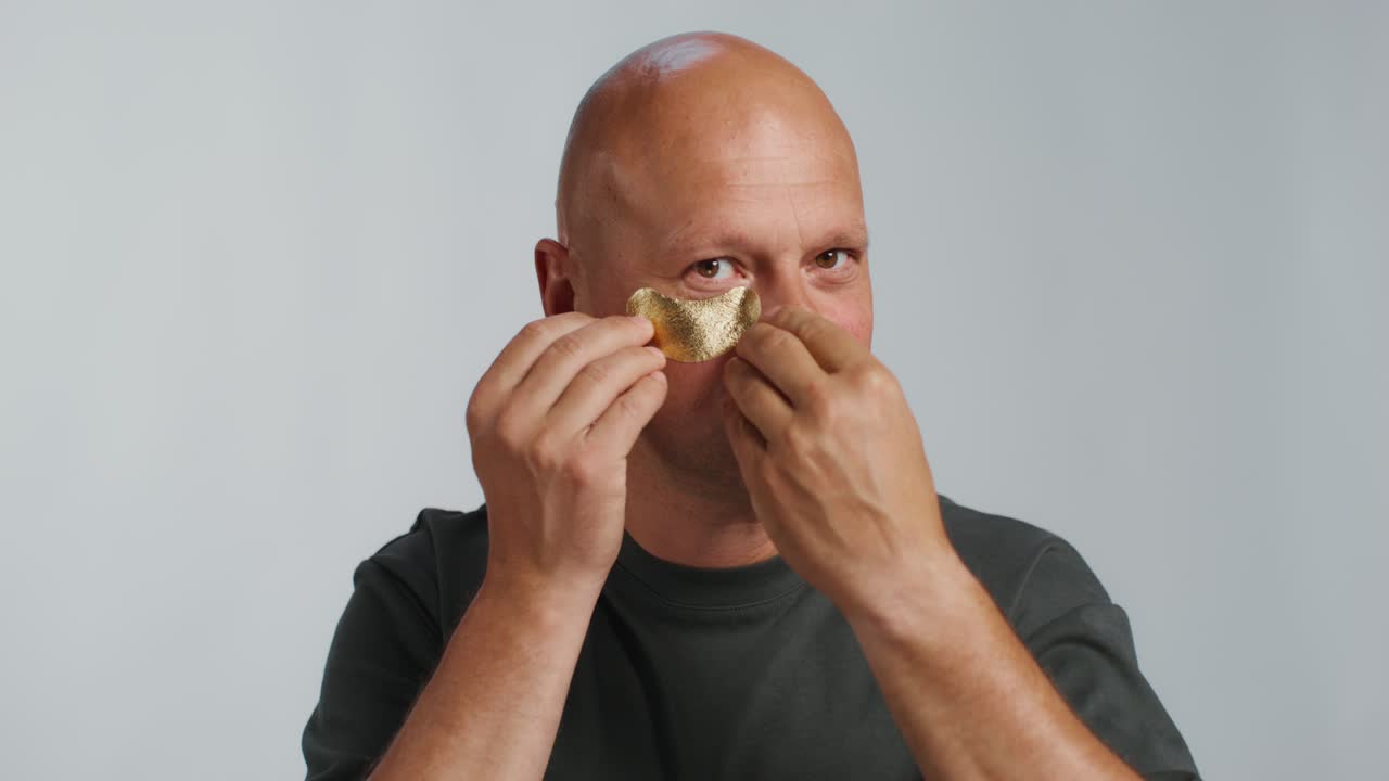 hombre aplicando una máscara facial de oro