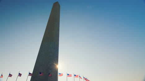 sun shines behind washington monument