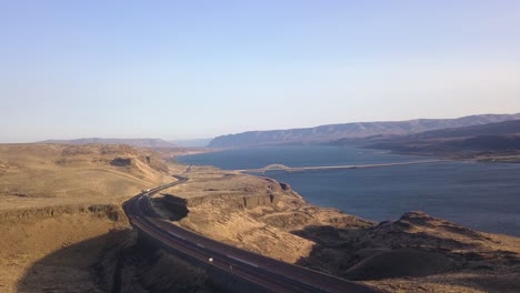 drone-with-arial-view-of-highway,-river-and-bridge