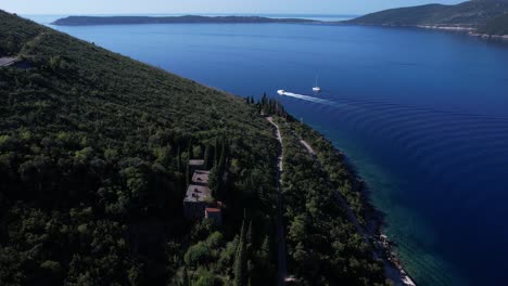 Vista-Aérea-Del-Barco-Navegando-En-La-Bahía-De-Kotor,-Montenegro-Con-La-Península-De-Prevlaka-Al-Fondo,-Croacia